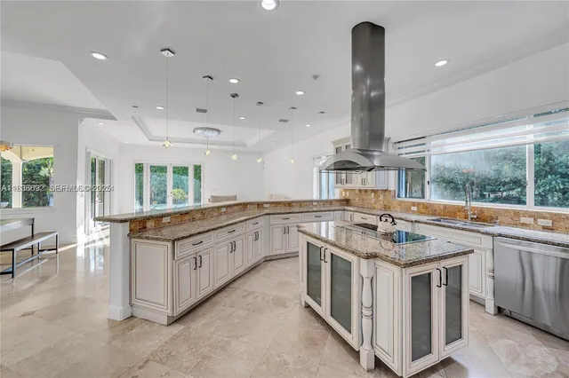 a bedroom with a large bed a chandelier and windows