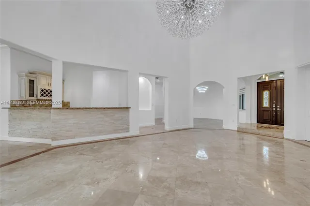 a large white kitchen with stainless steel appliances granite countertop a sink and cabinets