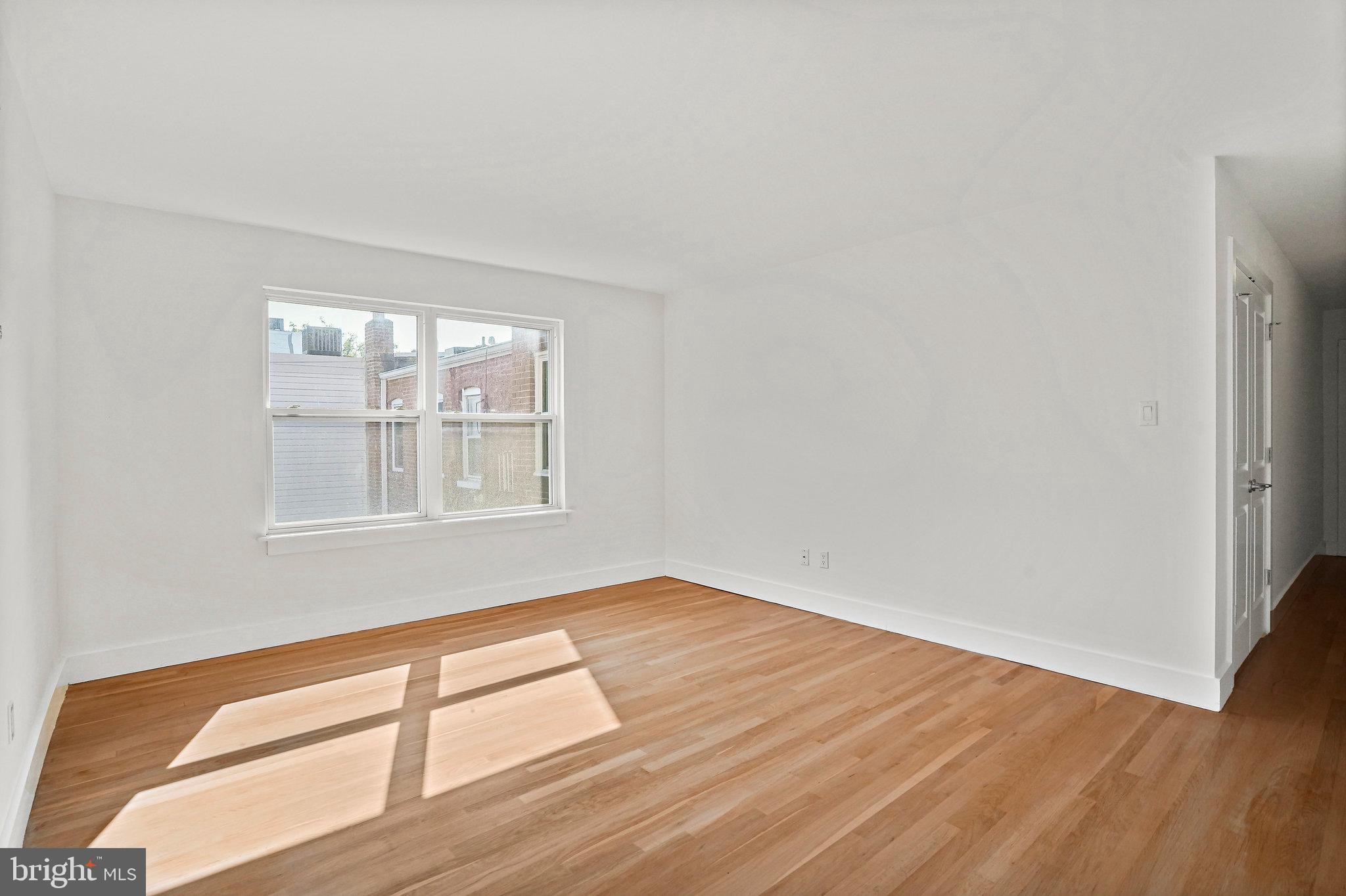 907 Euclid Street Northwest, Unit 203 Washington, DC 20001 - Photo 5 of 22 an empty room with wooden floor and windows