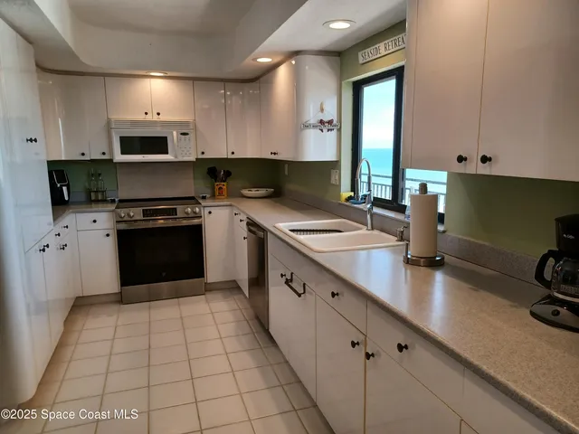 a kitchen with stainless steel appliances a sink dishwasher stove top oven and cabinets