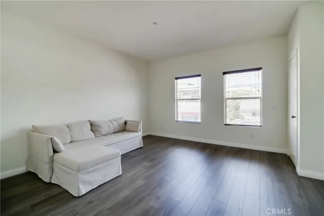 a living room with couches and a large window with wooden floor