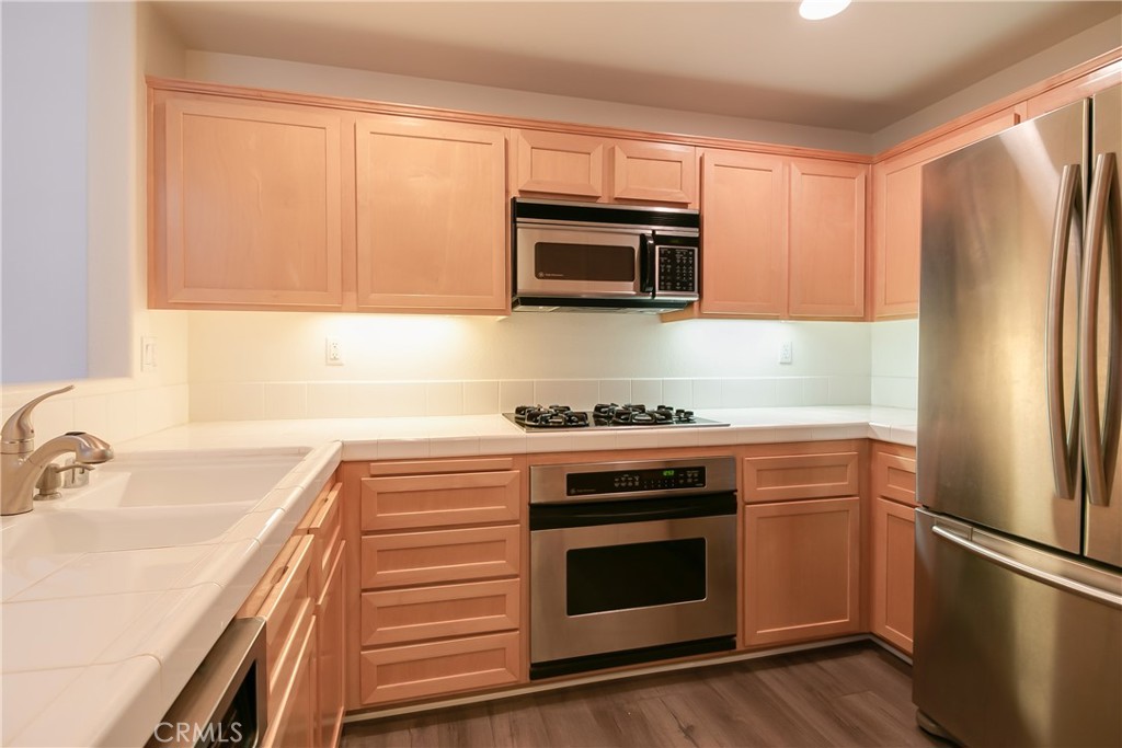 620 East Walnut Street Pasadena, CA 91101 - Photo 7 of 15 a kitchen with stainless steel appliances white cabinets and a stove top oven