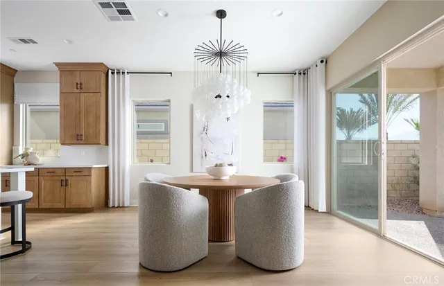 a kitchen with stainless steel appliances a dining table chairs and wooden floor
