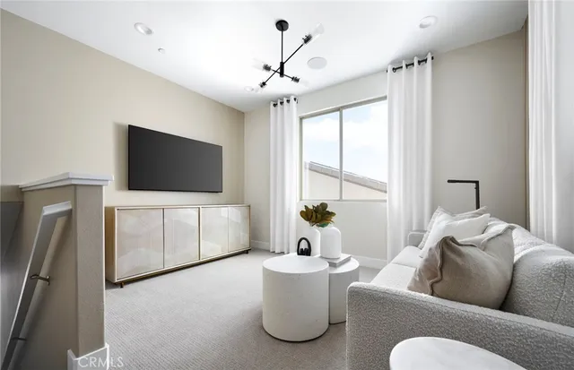 a living room with stainless steel appliances kitchen island a table and chairs