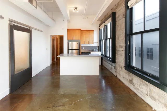 a kitchen with stainless steel appliances granite countertop a refrigerator a stove a sink and a cabinets