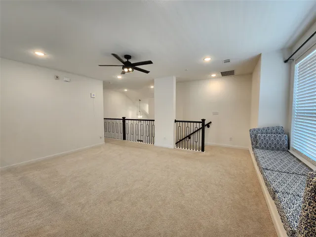 a living room with furniture and a ceiling fan