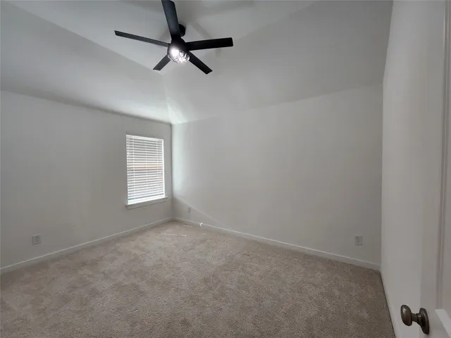 an empty room with closet and a ceiling fan