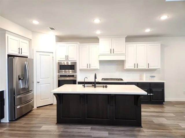 a kitchen with stainless steel appliances granite countertop a sink stove and refrigerator