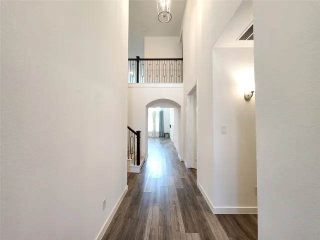 a view of a hallway with wooden floor and staircase