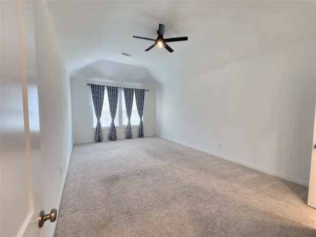 a view of an empty room with a ceiling fan