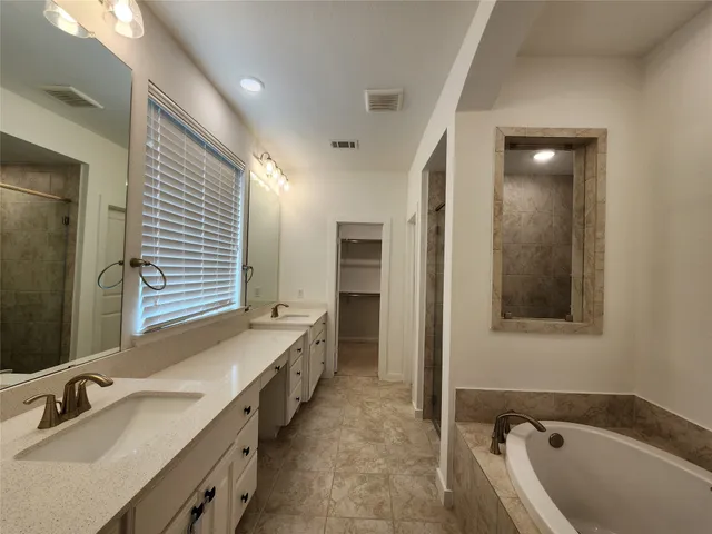 a bathroom with a tub sink and mirror
