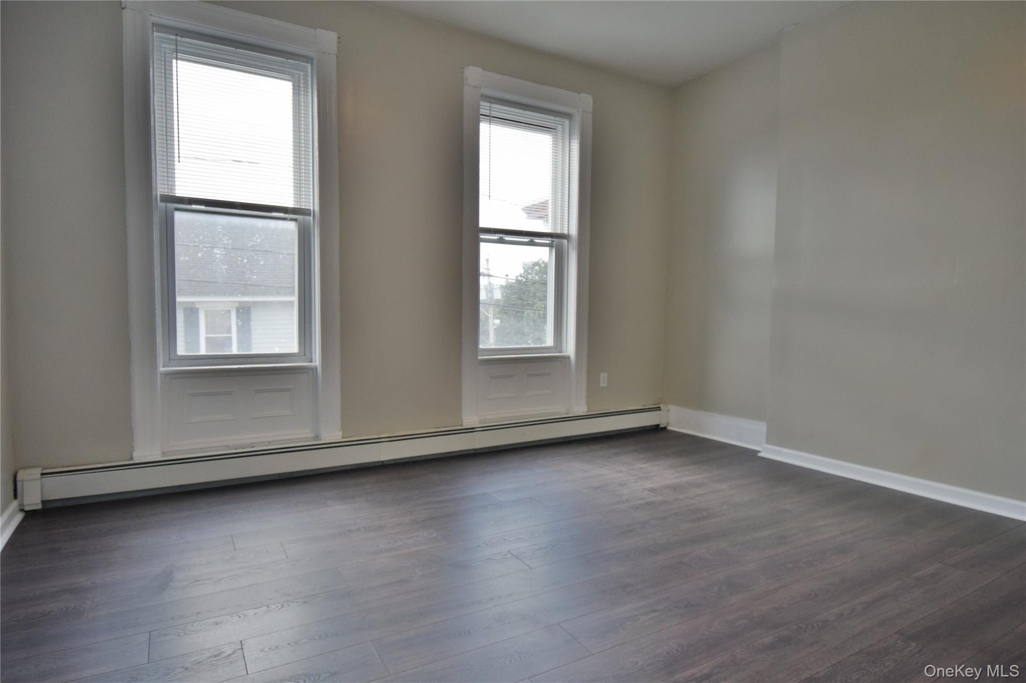 12 Railroad Avenue, Unit 2 Chester, NY 10918 - Photo 5 of 12 an empty room with wooden floor and windows