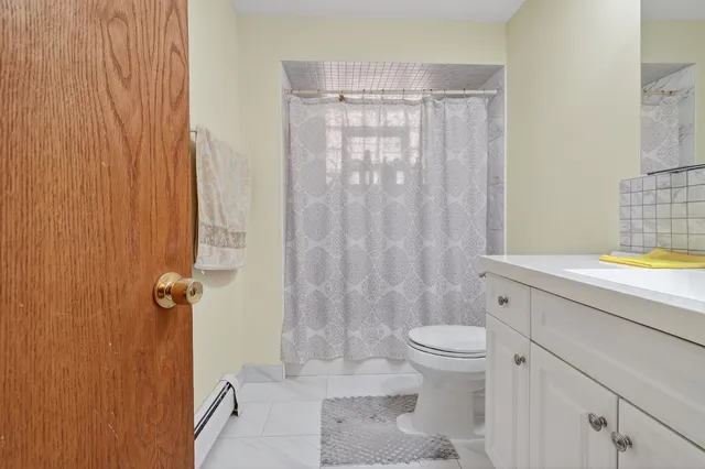 a bathroom with a granite countertop sink a toilet and shower