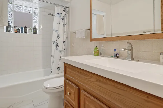 a bathroom with a granite countertop sink a toilet and bathtub