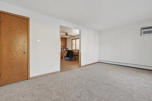 an empty room with a mirror and a chair