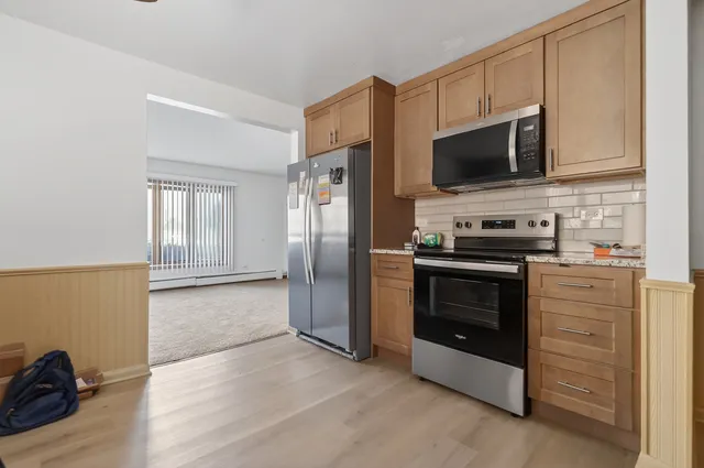 a kitchen with stainless steel appliances a stove microwave and refrigerator