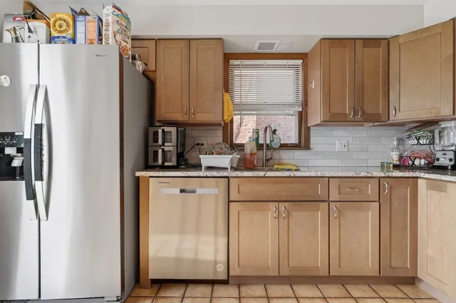 a kitchen with white cabinets and refrigerator
