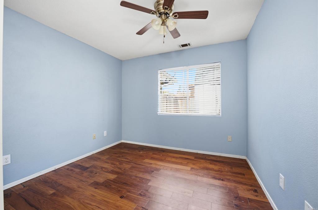 2077 Westwood Road Vista, CA 92083 - Photo 17 of 37 an empty room with wooden floor fan and windows
