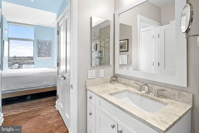 a en suite bathroom with a granite countertop sink and a mirror