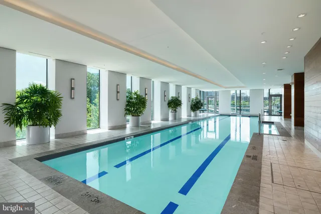 a large swimming pool with large glass windows and table