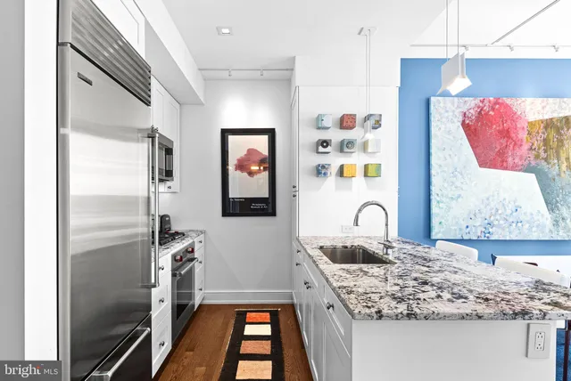 a kitchen with stainless steel appliances granite countertop a refrigerator and a stove