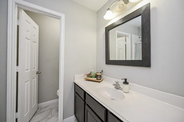a bathroom with a sink vanity and mirror