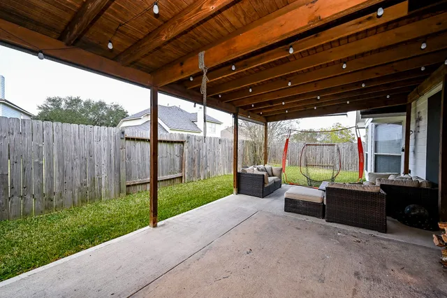 a view of a backyard with couches plants and wooden fence