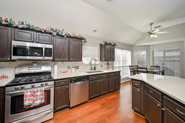 a kitchen with stainless steel appliances a stove sink microwave and cabinets
