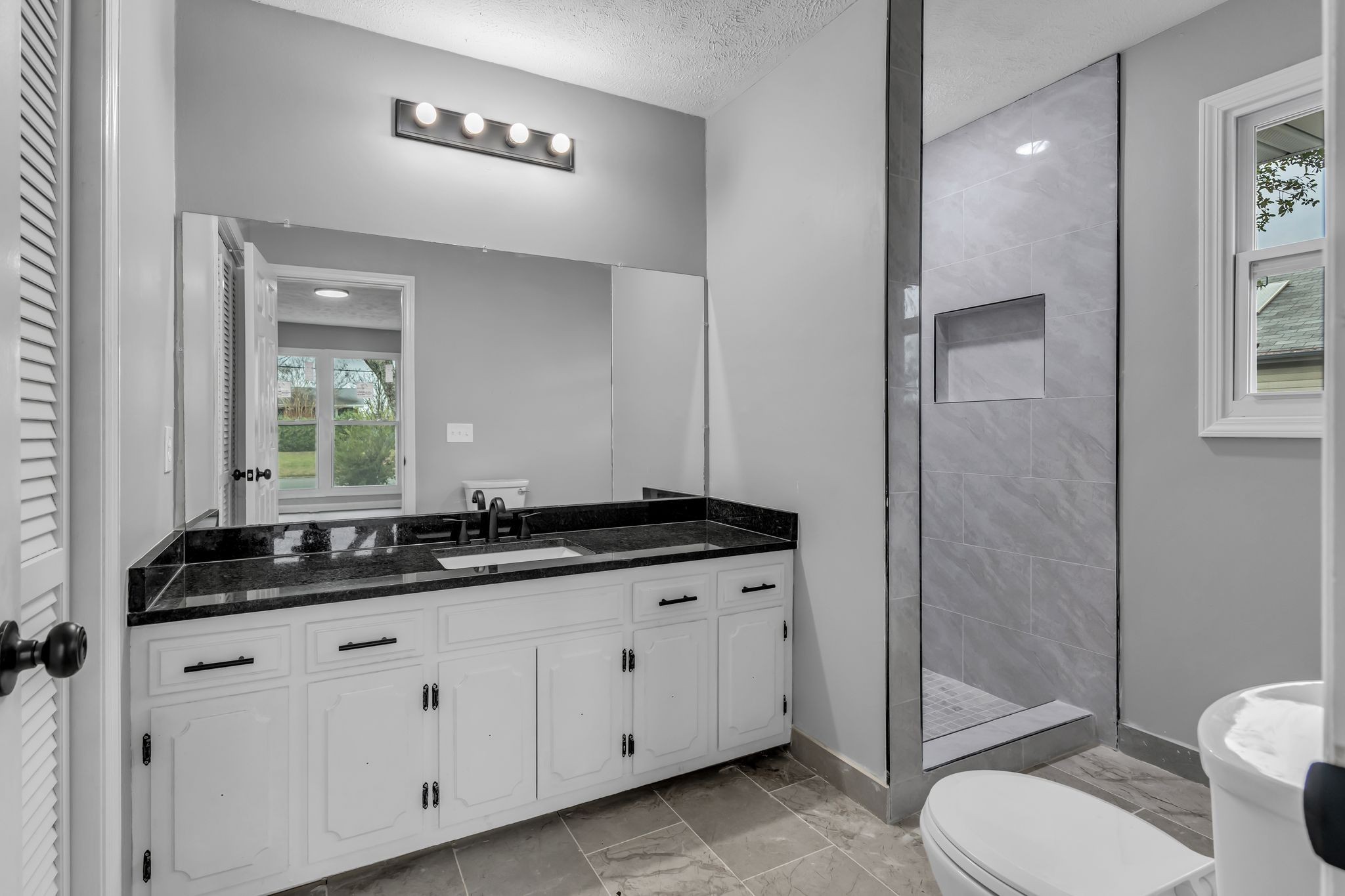 200 Upwind Court Nashville, TN 37217 - Photo 30 of 49 a bathroom with a granite countertop sink a toilet a mirror and shower