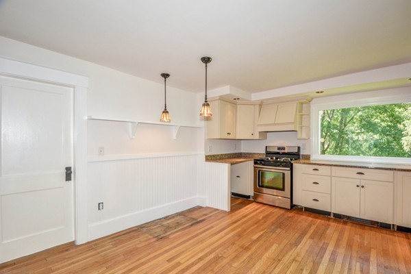 7 Martin Street Maynard, MA 01754 - Photo 7 of 28 a kitchen with stainless steel appliances white cabinets and wooden floors