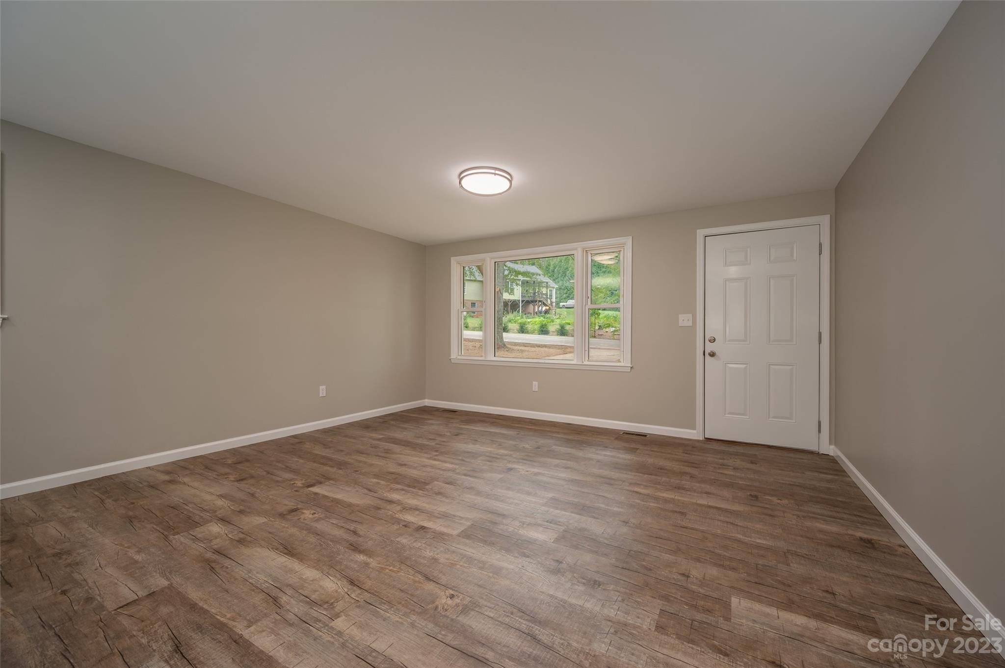 606 Edwards Street Rutherfordton, NC 28139 - Photo 3 of 29 an empty room with wooden floor and windows