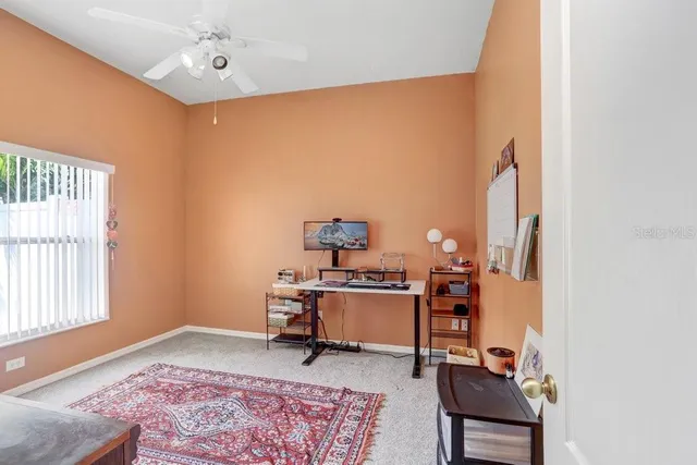 a view of a workspace with furniture and a window