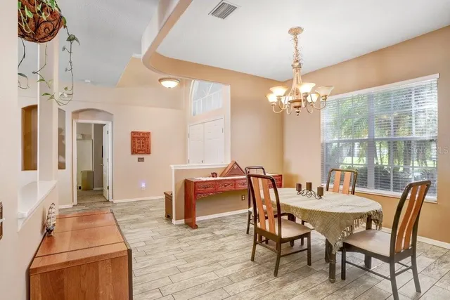 a dining room with furniture a chandelier and wooden floor