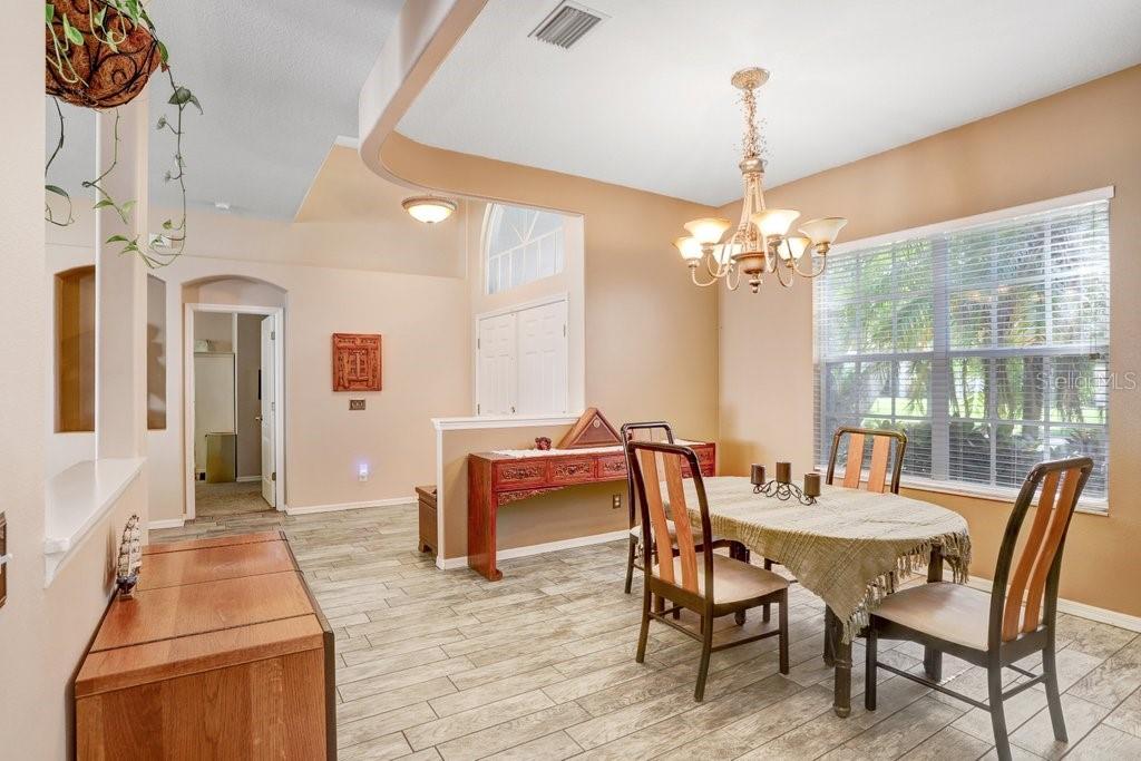 829 Innergary Place Valrico, FL 33594 - Photo 2 of 30 a dining room with furniture a chandelier and wooden floor