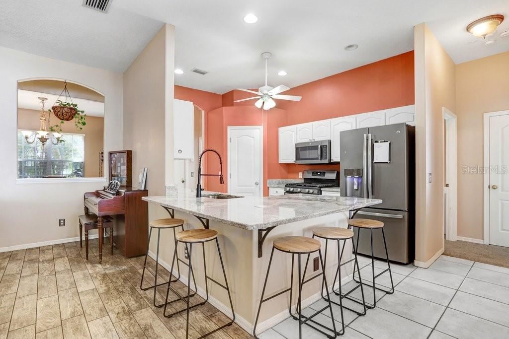 829 Innergary Place Valrico, FL 33594 - Photo 8 of 30 a kitchen with stainless steel appliances kitchen island granite countertop furniture and a view of living room