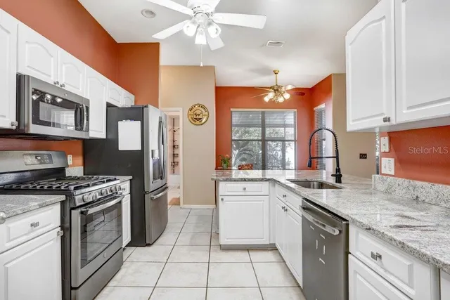 a kitchen with stainless steel appliances granite countertop a stove sink and cabinets