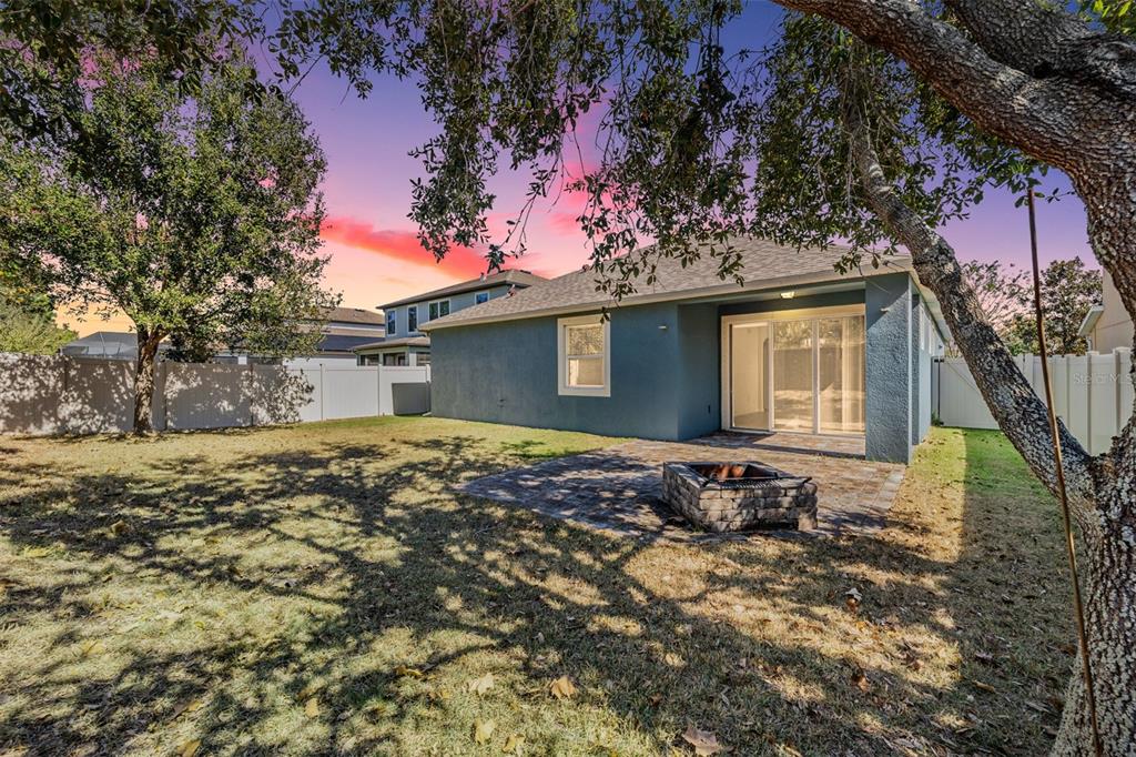 1570 Fox Grape Loop Lutz, FL 33558 - Photo 28 of 41 a backyard of a house with table and chairs under an umbrella