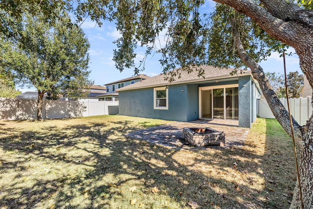1570 Fox Grape Loop Lutz, FL 33558 - Photo 37 of 41 a backyard of a house with large trees and wooden fence