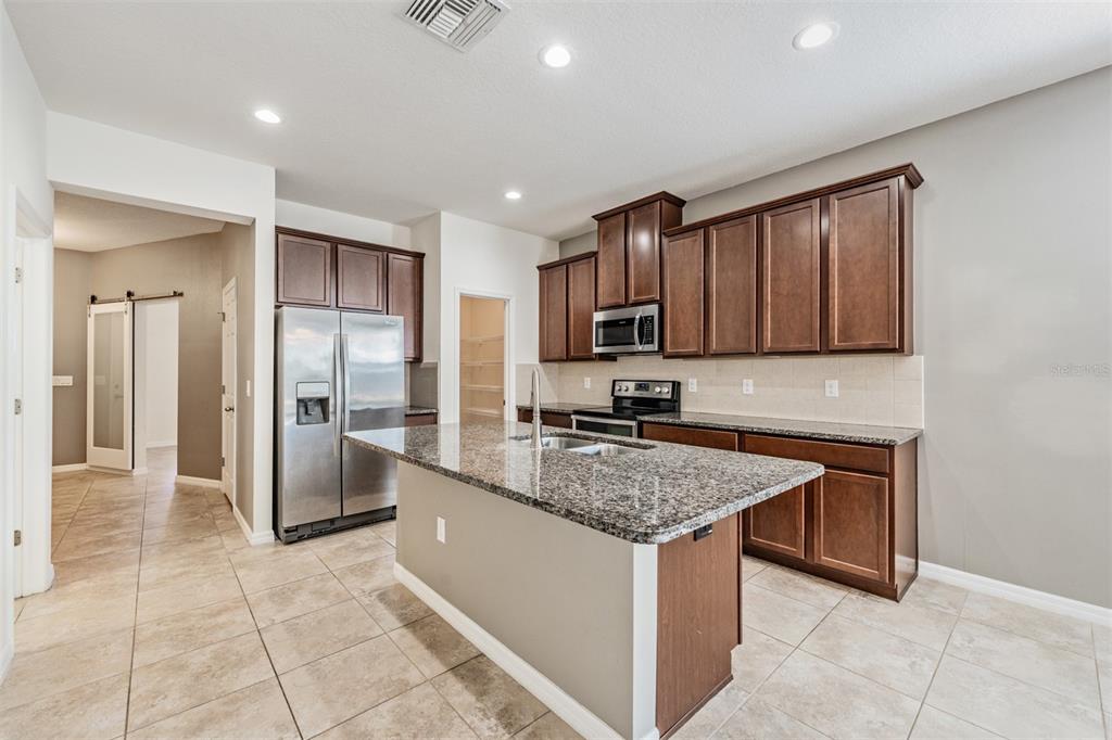 1570 Fox Grape Loop Lutz, FL 33558 - Photo 7 of 41 a kitchen with stainless steel appliances granite countertop a refrigerator and a sink