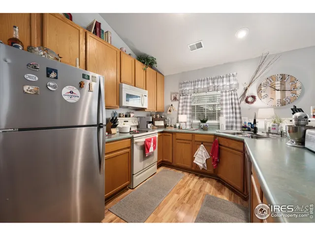 a kitchen with stainless steel appliances granite countertop a sink stove and wooden cabinets