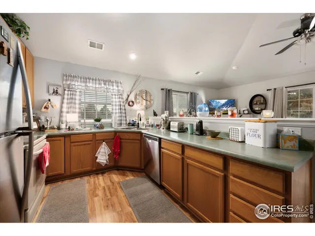 a open kitchen with stainless steel appliances granite countertop a sink dishwasher with a dining table and chairs with wooden floor
