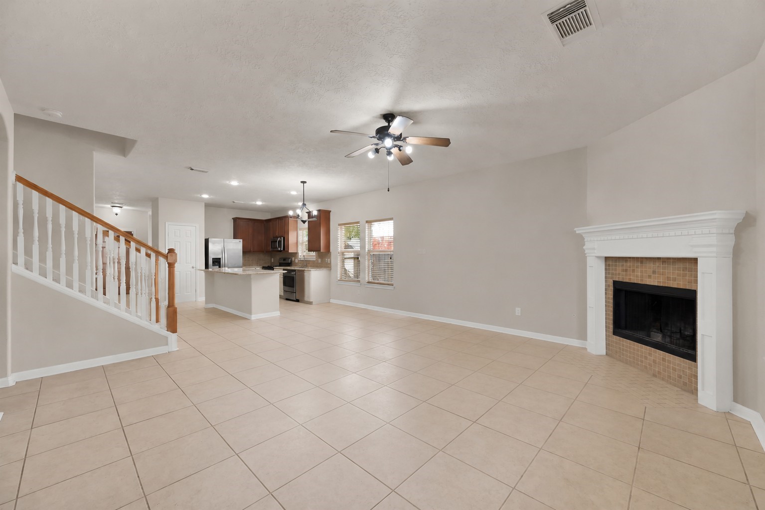 1443 Meadowhigh Lane Spring, TX 77373 - Photo 3 of 23 a view of a livingroom with a fireplace a chandelier a ceiling fan and windows