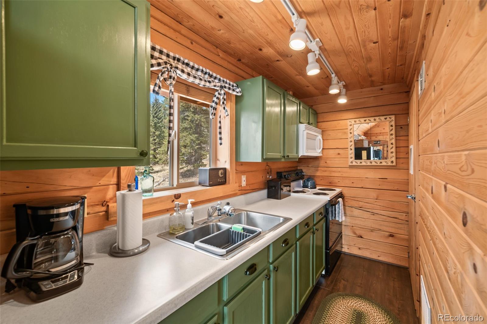 858 Red Cloud Road Jefferson, CO 80456 - Photo 20 of 32 a kitchen with a sink and a stove next to a window
