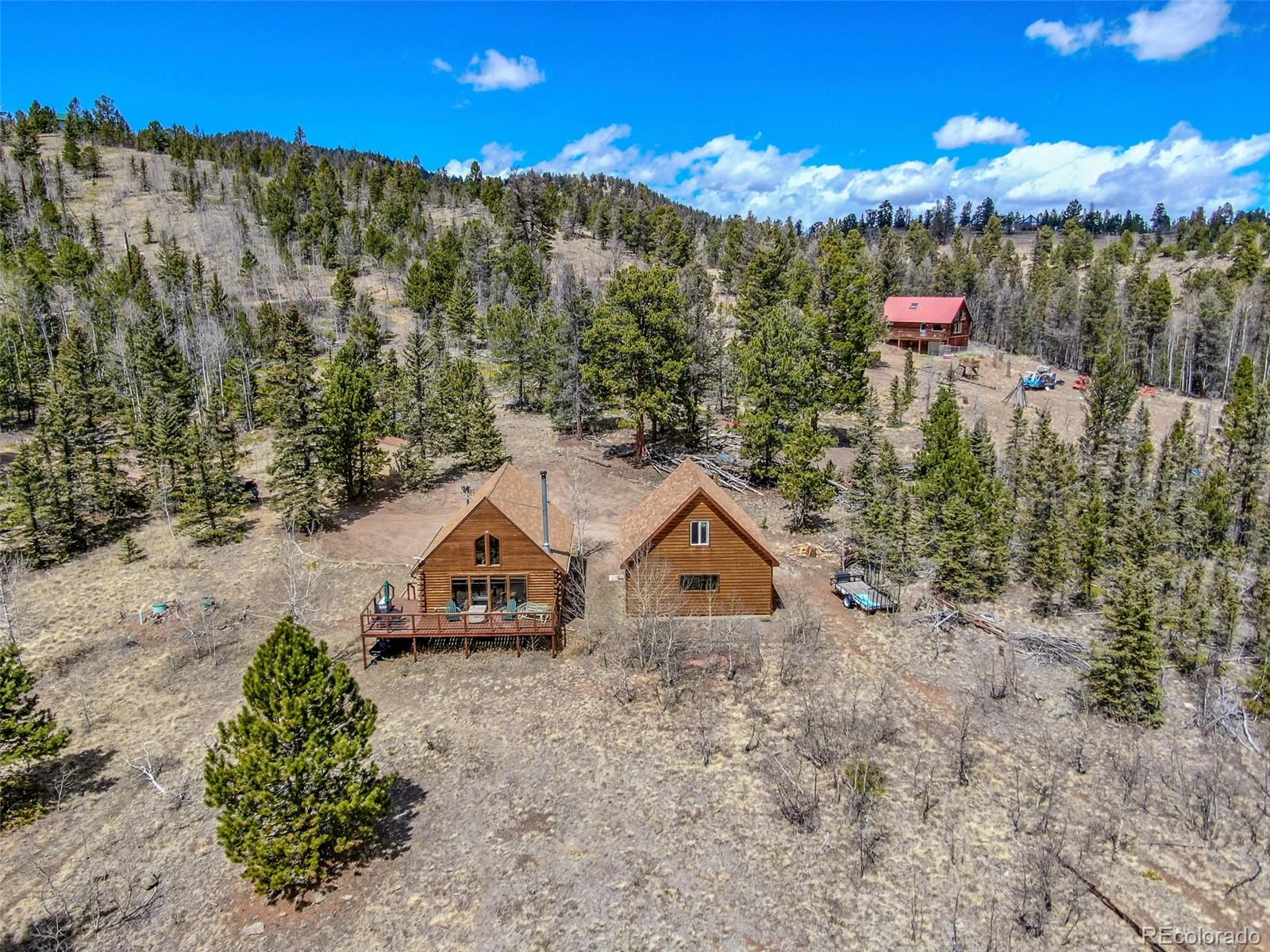 858 Red Cloud Road Jefferson, CO 80456 - Photo 3 of 32 a view of a wooden house with a yard and large trees