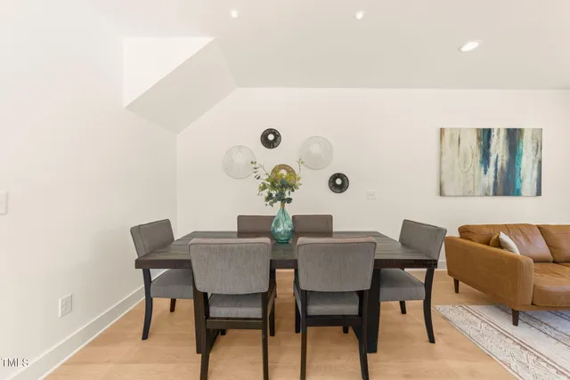 a kitchen with stainless steel appliances a sink a stove a refrigerator and white cabinets with wooden floor