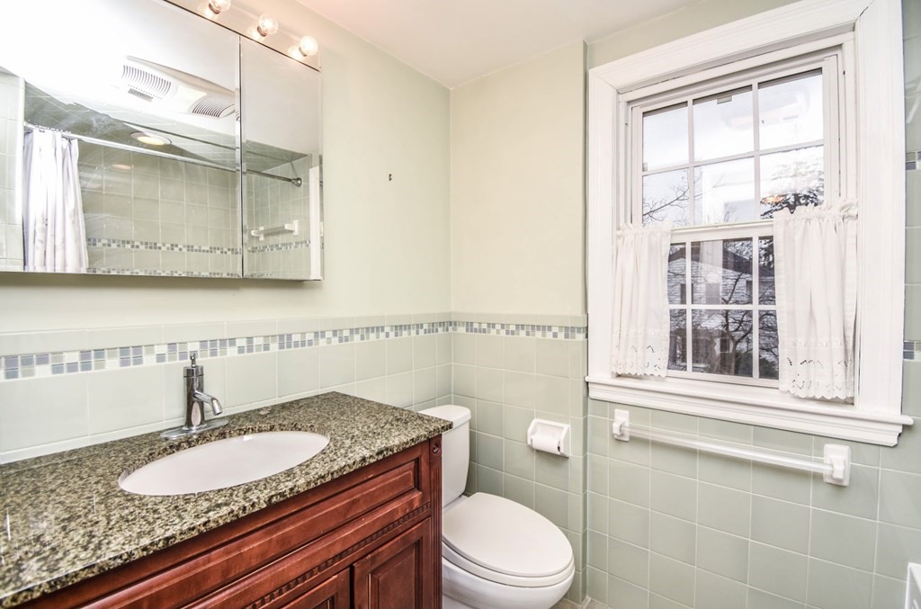 77 Hagen Road Newton, MA 02459 - Photo 18 of 18 a bathroom with a granite countertop toilet a sink and mirror