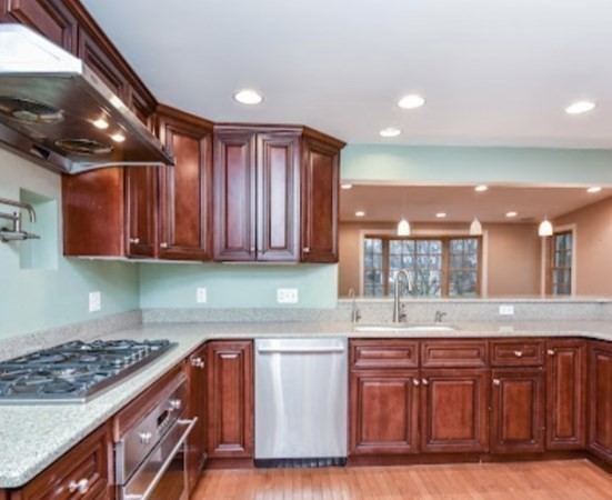 77 Hagen Road Newton, MA 02459 - Photo 3 of 18 a kitchen with wooden cabinets and a stove top oven