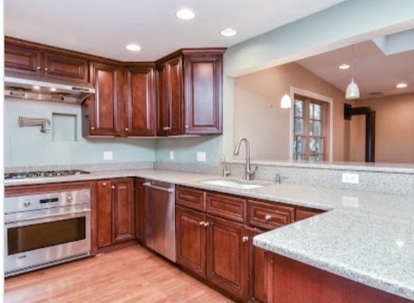 77 Hagen Road Newton, MA 02459 - Photo 4 of 18 a kitchen with stainless steel appliances granite countertop a sink stove and oven