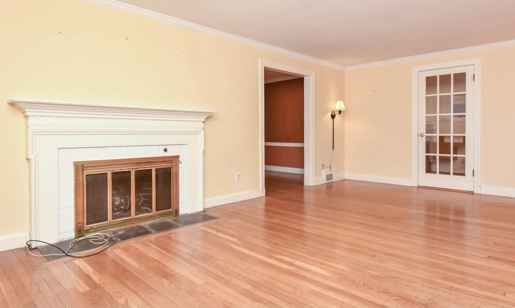 77 Hagen Road Newton, MA 02459 - Photo 8 of 18 a view of an empty room with wooden floor and a fireplace