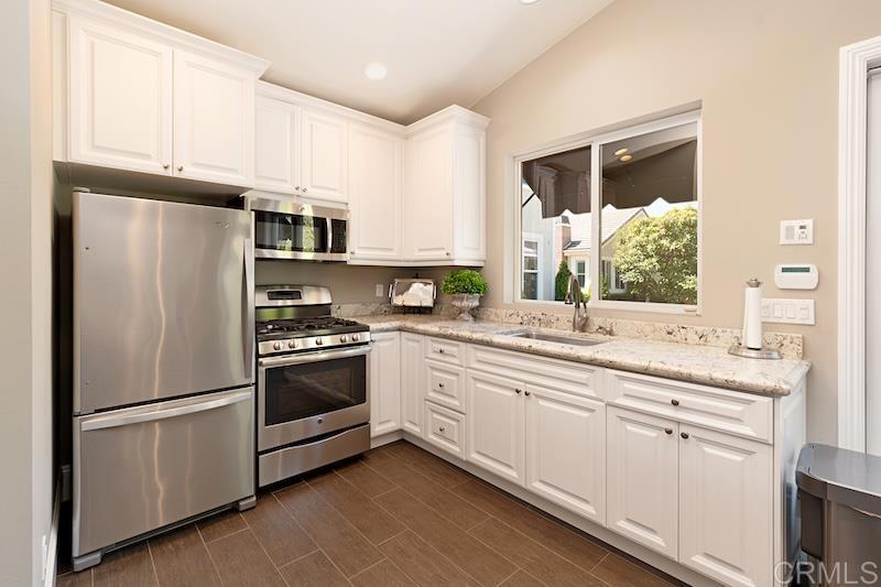6301 Allston Street Carlsbad, CA 92009 - Photo 39 of 73 a kitchen with stainless steel appliances white cabinets and a refrigerator